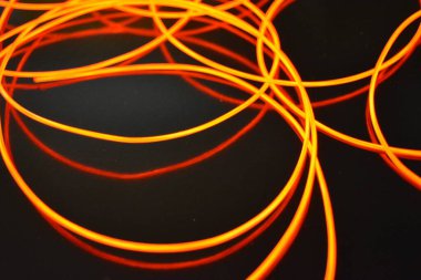 Sıra dışı parlak kırmızı iplik, bükülmüş tel, yapısal ve kıvrımlı kablo. Neon elektroaydınlatma kablosu, kablo, plastik neon ışıkla eşit derecede parlar..