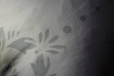 Eşyalar, nesneler, yoğun doğal arkaplan beyaz çiçekli gri kumaşlar ve beyaz iplikçikler.