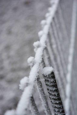 Eskrim, metal çubuklar, ince metal raptiyeler, parlak beyaz karla kaplı tel örgüler..