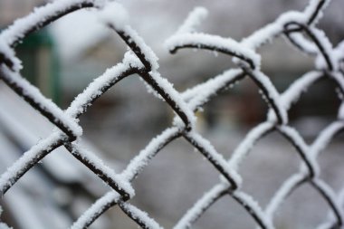 Eskrim, metal çubuklar, ince metal raptiyeler, parlak beyaz karla kaplı tel örgüler..