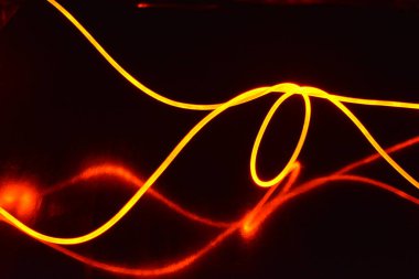 Güzel ve alışılmadık grafik arka plan. Çok renkli ışık, ışık demetleri plastik bükülmüş borulardan geçiyor. Parlayan plastik, kırmızı, sarı, beyaz, mor, yeşil, turuncu, mavi, taşmış ve açık mavi.