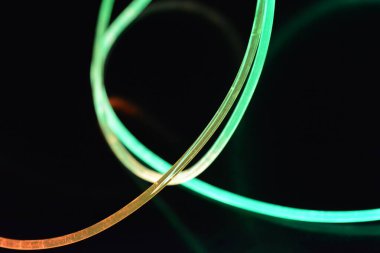 Güzel ve alışılmadık grafik arka plan. Çok renkli ışık, ışık demetleri plastik bükülmüş borulardan geçiyor. Parlayan plastik, kırmızı, sarı, beyaz, mor, yeşil, turuncu, mavi, taşmış ve açık mavi.