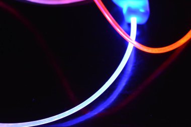 Güzel ve alışılmadık grafik arka plan. Çok renkli ışık, ışık demetleri plastik bükülmüş borulardan geçiyor. Parlayan plastik, kırmızı, sarı, beyaz, mor, yeşil, turuncu, mavi, taşmış ve açık mavi.