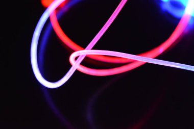 Güzel ve alışılmadık grafik arka plan. Çok renkli ışık, ışık demetleri plastik bükülmüş borulardan geçiyor. Parlayan plastik, kırmızı, sarı, beyaz, mor, yeşil, turuncu, mavi, taşmış ve açık mavi.