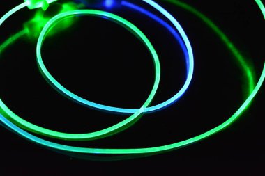 Güzel ve alışılmadık grafik arka plan. Çok renkli ışık, ışık demetleri plastik bükülmüş borulardan geçiyor. Parlayan plastik, kırmızı, sarı, beyaz, mor, yeşil, turuncu, mavi, taşmış ve açık mavi.