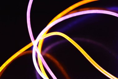 Güzel ve alışılmadık grafik arka plan. Çok renkli ışık, ışık demetleri plastik bükülmüş borulardan geçiyor. Parlayan plastik, kırmızı, sarı, beyaz, mor, yeşil, turuncu, mavi, taşmış ve açık mavi.