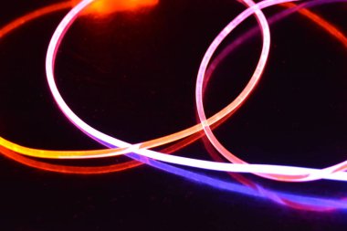 Güzel ve alışılmadık grafik arka plan. Çok renkli ışık, ışık demetleri plastik bükülmüş borulardan geçiyor. Parlayan plastik, kırmızı, sarı, beyaz, mor, yeşil, turuncu, mavi, taşmış ve açık mavi.