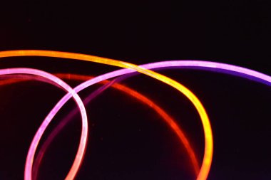 Güzel ve alışılmadık grafik arka plan. Çok renkli ışık, ışık demetleri plastik bükülmüş borulardan geçiyor. Parlayan plastik, kırmızı, sarı, beyaz, mor, yeşil, turuncu, mavi, taşmış ve açık mavi.