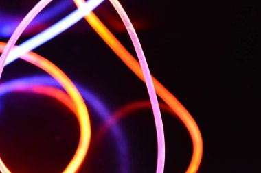 Güzel ve alışılmadık grafik arka plan. Çok renkli ışık, ışık demetleri plastik bükülmüş borulardan geçiyor. Parlayan plastik, kırmızı, sarı, beyaz, mor, yeşil, turuncu, mavi, taşmış ve açık mavi.