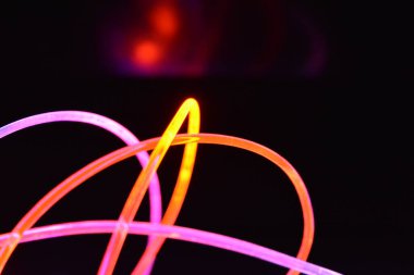 Güzel ve alışılmadık grafik arka plan. Çok renkli ışık, ışık demetleri plastik bükülmüş borulardan geçiyor. Parlayan plastik, kırmızı, sarı, beyaz, mor, yeşil, turuncu, mavi, taşmış ve açık mavi.