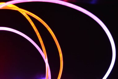 Güzel ve alışılmadık grafik arka plan. Çok renkli ışık, ışık demetleri plastik bükülmüş borulardan geçiyor. Parlayan plastik, kırmızı, sarı, beyaz, mor, yeşil, turuncu, mavi, taşmış ve açık mavi.