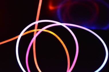 Güzel ve alışılmadık grafik arka plan. Çok renkli ışık, ışık demetleri plastik bükülmüş borulardan geçiyor. Parlayan plastik, kırmızı, sarı, beyaz, mor, yeşil, turuncu, mavi, taşmış ve açık mavi.