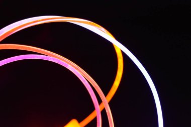 Güzel ve alışılmadık grafik arka plan. Çok renkli ışık, ışık demetleri plastik bükülmüş borulardan geçiyor. Parlayan plastik, kırmızı, sarı, beyaz, mor, yeşil, turuncu, mavi, taşmış ve açık mavi.