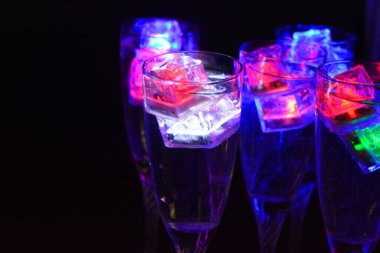 Parlayan şeylerin olduğu bir parti. Renkli bardaklar, köpüklü şampanya bardakları, karbonatlı tatlı su, parlayan buz küpleri, donmuş buz. Kırmızı, mavi, yeşil, sarı, beyaz ışık içecekleri içinde yüzen LED 'li plastik buz küpleri.