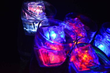 Parlayan şeylerin olduğu bir parti. Renkli bardaklar, köpüklü şampanya bardakları, karbonatlı tatlı su, parlayan buz küpleri, donmuş buz. Kırmızı, mavi, yeşil, sarı, beyaz ışık içecekleri içinde yüzen LED 'li plastik buz küpleri.