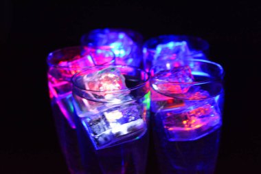 Parlayan şeylerin olduğu bir parti. Renkli bardaklar, köpüklü şampanya bardakları, karbonatlı tatlı su, parlayan buz küpleri, donmuş buz. Kırmızı, mavi, yeşil, sarı, beyaz ışık içecekleri içinde yüzen LED 'li plastik buz küpleri.