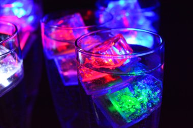 Parlayan şeylerin olduğu bir parti. Renkli bardaklar, köpüklü şampanya bardakları, karbonatlı tatlı su, parlayan buz küpleri, donmuş buz. Kırmızı, mavi, yeşil, sarı, beyaz ışık içecekleri içinde yüzen LED 'li plastik buz küpleri.