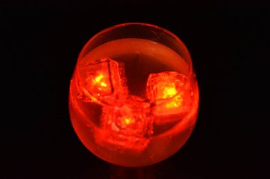 Parlayan şeylerin olduğu bir parti. Renkli bardaklar, köpüklü şampanya bardakları, karbonatlı tatlı su, parlayan buz küpleri, donmuş buz. Kırmızı, mavi, yeşil, sarı, beyaz ışık içecekleri içinde yüzen LED 'li plastik buz küpleri.