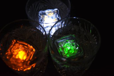 Parlayan şeylerin olduğu bir parti. Renkli bardaklar, köpüklü şampanya bardakları, karbonatlı tatlı su, parlayan buz küpleri, donmuş buz. Kırmızı, mavi, yeşil, sarı, beyaz ışık içecekleri içinde yüzen LED 'li plastik buz küpleri.