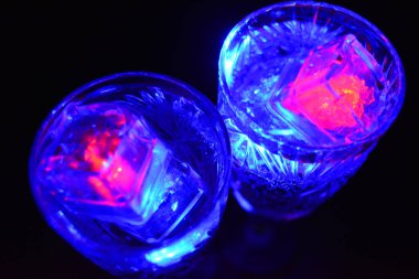 Parlayan şeylerin olduğu bir parti. Renkli bardaklar, köpüklü şampanya bardakları, karbonatlı tatlı su, parlayan buz küpleri, donmuş buz. Kırmızı, mavi, yeşil, sarı, beyaz ışık içecekleri içinde yüzen LED 'li plastik buz küpleri.