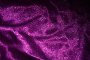 Kumaşlar, giysiler, nesneler, koyu mor arka planlar. Güzel parlak kadifemsi mor kumaş. İlginç bir parıltı, yansıması var..