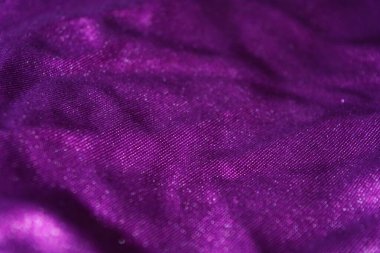 Kumaşlar, giysiler, nesneler, koyu mor arka planlar. Güzel parlak kadifemsi mor kumaş. İlginç bir parıltı, yansıması var..