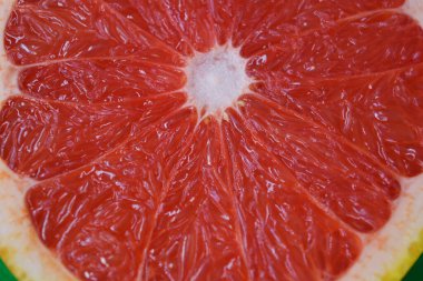 Sağlık, sağlıklı yaşam tarzı, gıda kültürü, sağlıklı meyveler. Meyvelerin güzel meyveleri, sulu, olgun kırmızı, turuncu greyfurt, meyvenin yarıları beyaz plastik arka planda yer alır..