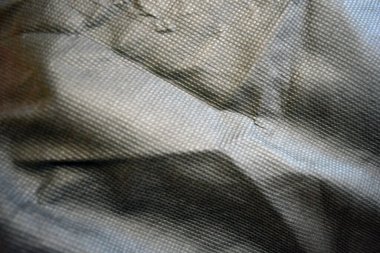 Paketleme malzemeleri, siyah sentetik kumaş iyi bir açıda duruyor. Küçük kareler şeklinde alışılmadık gri, açık siyah bir arkaplan..