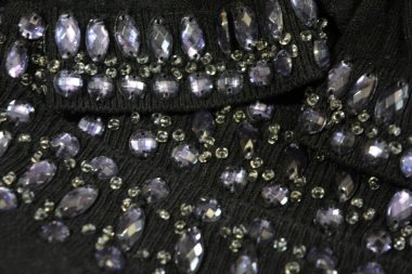 Parlak, sıra dışı, parlak mavi, gri taşlar, koluna işlemeli boncuklu mücevherler, siyah kadın pamuğundan kollar, örülmüş süveter..