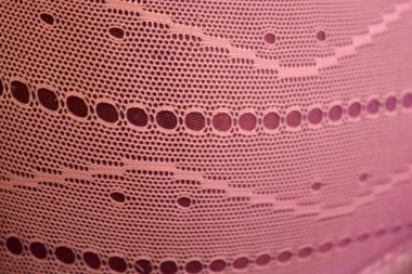 Alışılmadık malzemeler, arka planlar, sentetik kumaşlar. Mor ince kumaş örgüsü mor parlak kumaşın üzerinde bulunur..