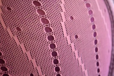 Alışılmadık malzemeler, arka planlar, sentetik kumaşlar. Mor ince kumaş örgüsü mor parlak kumaşın üzerinde bulunur..