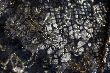 Altın kaplamalı siyah kumaş arkaplan, yansıtıcı plastik pullu altın çiçek desenleri.