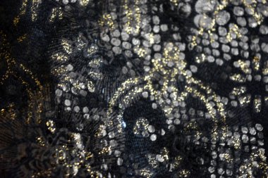 Altın kaplamalı siyah kumaş arkaplan, yansıtıcı plastik pullu altın çiçek desenleri.