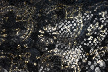 Altın kaplamalı siyah kumaş arkaplan, yansıtıcı plastik pullu altın çiçek desenleri.