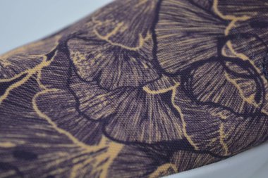 Alışılmadık bir kumaş mor, turuncu arkaplan ve yapraklar şeklinde bir desen. Yoğun, eşsiz renkte pamuk kumaş..