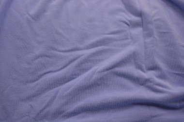 Sıra dışı mavi ince yaz kumaşı. Pamuk, sentetik, yumuşak kumaş, kadın giysileri beyaz plastik arka planda bulunur..