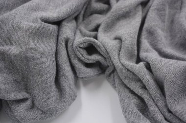 Alışılmadık gri ince yaz kumaşı. Sentetik, yumuşak kumaş beyaz plastik arka plana yerleştiriliyor..