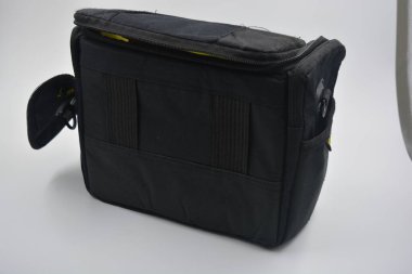 Çantalar, fermuarlı ürünler günlük yaşam için. Sarı astarlı, siyah fermuarlı ve cepli kırılgan ekipmanları saklamak ve taşımak için küçük siyah bir çanta beyaz arka planda yer almaktadır..