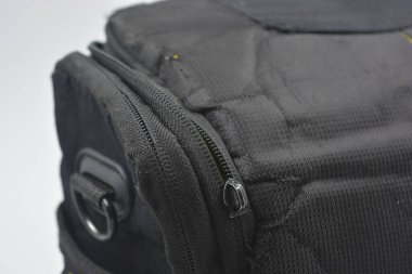 Çantalar, fermuarlı ürünler günlük yaşam için. Sarı astarlı, siyah fermuarlı ve cepli kırılgan ekipmanları saklamak ve taşımak için küçük siyah bir çanta beyaz arka planda yer almaktadır..