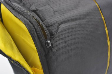 Çantalar, fermuarlı ürünler günlük yaşam için. Sarı astarlı, siyah fermuarlı ve cepli kırılgan ekipmanları saklamak ve taşımak için küçük siyah bir çanta beyaz arka planda yer almaktadır..