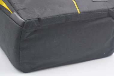 Çantalar, fermuarlı ürünler günlük yaşam için. Sarı astarlı, siyah fermuarlı ve cepli kırılgan ekipmanları saklamak ve taşımak için küçük siyah bir çanta beyaz arka planda yer almaktadır..
