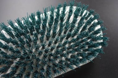 Yeşil tüylü büyük plastik oval beyaz fırça temizlik halıları için, şeyler siyah plastik arka planda yer almaktadır.