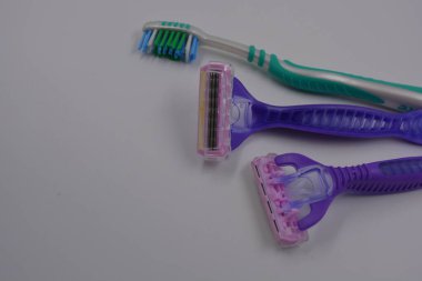 Kadın eşyaları, plastikten yapılmıştır. Koltuk altı olmak için iki kadın mor makinesi, siyah plastik arka planda yeşil bir kadın diş fırçası..