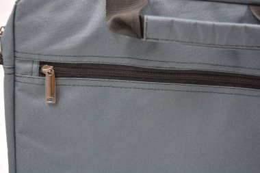 Günlük eşyalar, ekipmanlar, yeşil, gri, siyah metal fermuarlı yumuşak laptop çantası siyah plastik bir arka planda yer almaktadır..