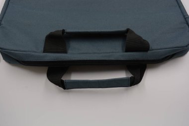 Günlük eşyalar, ekipmanlar, yeşil, gri, siyah metal fermuarlı yumuşak laptop çantası siyah plastik bir arka planda yer almaktadır..