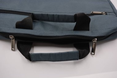 Günlük eşyalar, ekipmanlar, yeşil, gri, siyah metal fermuarlı yumuşak laptop çantası siyah plastik bir arka planda yer almaktadır..