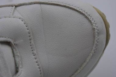 Kumaş arka plan, beyaz deri kumaştan malzemeler, plastik, kauçuk. Beyaz yüzey beyaz ipliklerle dikilmiş, malzeme yıpranmış..