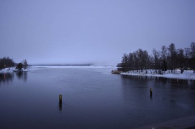 Finlandiya 'nın başkenti Varkaus' un orta kesiminde renkli bir manzara. Olağandışı parlak Finlandiya binaları, yapıları, alışılmadık ağaçları olan evler, göl veya nehir kıyısında bulunan köknar ağaçları..