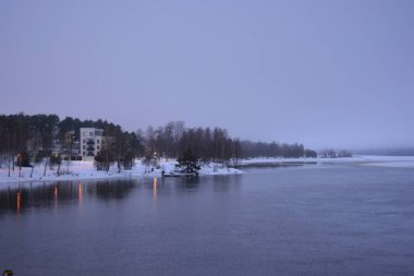 Finlandiya 'nın başkenti Varkaus' un orta kesiminde renkli bir manzara. Olağandışı parlak Finlandiya binaları, yapıları, alışılmadık ağaçları olan evler, göl veya nehir kıyısında bulunan köknar ağaçları..