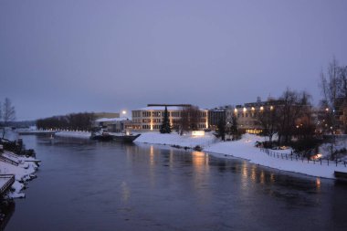 Finlandiya 'nın başkenti Varkaus' un orta kesiminde renkli bir manzara. Olağandışı parlak Finlandiya binaları, yapıları, alışılmadık ağaçları olan evler, göl veya nehir kıyısında bulunan köknar ağaçları..